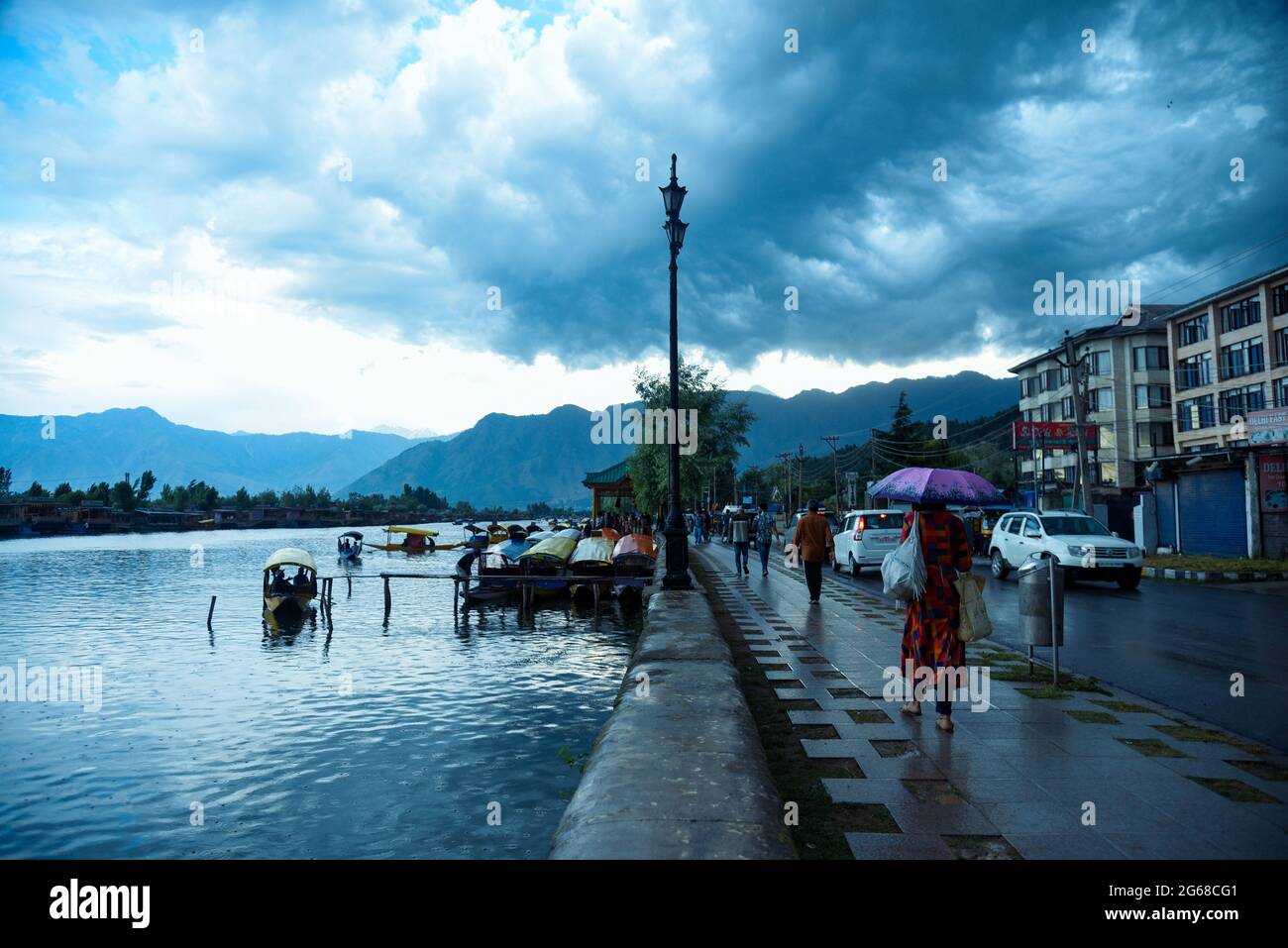 Srinagar, Indien. Juli 2021. Während der Regenfälle laufen die Menschen am Ufer des Dal-Sees entlang. Wettermänner prognostizierten für die nächsten fünf Tage hauptsächlich „heißes und trockenes“ Wetter in Jammu und Kaschmir. (Foto von Idrees Abbas/SOPA Images/Sipa USA) Quelle: SIPA USA/Alamy Live News Stockfoto