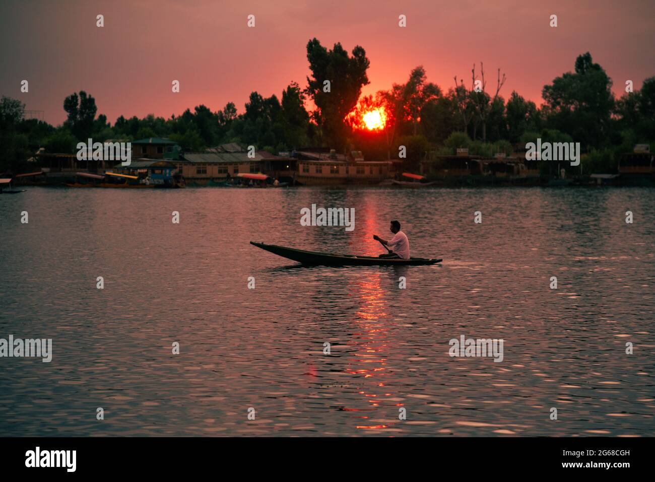 Srinagar, Indien. Juli 2021. Ein Mann rudert während des Sonnenuntergangs auf dem Wasser des Dal Lake. Wettermänner prognostizierten für die nächsten fünf Tage hauptsächlich „heißes und trockenes“ Wetter in Jammu und Kaschmir. (Foto von Idrees Abbas/SOPA Images/Sipa USA) Quelle: SIPA USA/Alamy Live News Stockfoto