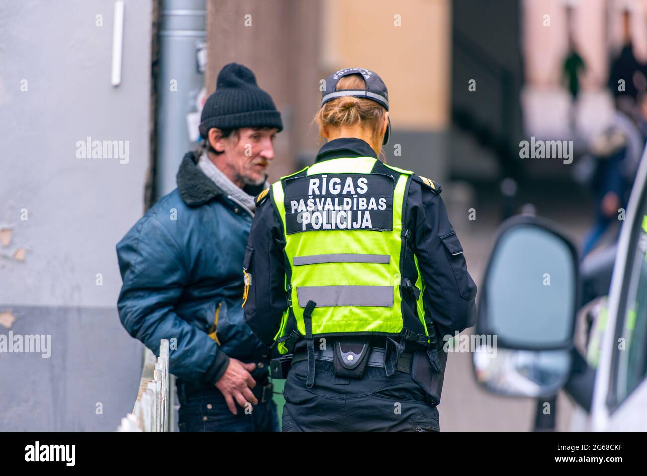 RIGA - Okt 07: Polizist der Stadtpolizei Riga und armer Mann in einer Straße von Riga, Oktober 07. 10. 2018 in Lettland Stockfoto