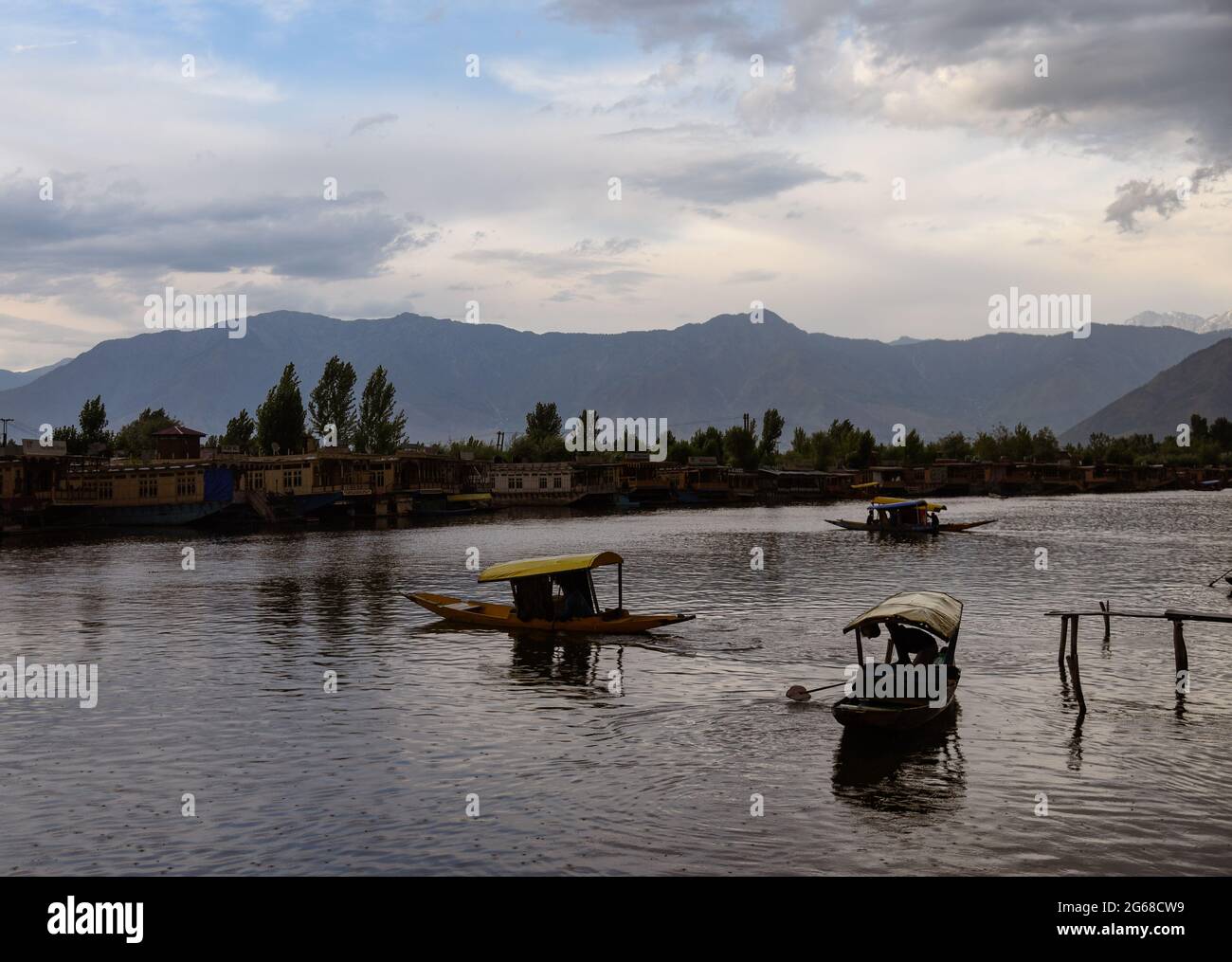 Srinagar, Indien. Juli 2021. Kashmiri-Männer rudern bei Regen ihre Shikara-Boote auf dem Dal-See. Wettermänner prognostizierten für die nächsten fünf Tage vor allem „heißes und trockenes“ Wetter in Jammu und Kaschmir. Kredit: SOPA Images Limited/Alamy Live Nachrichten Stockfoto