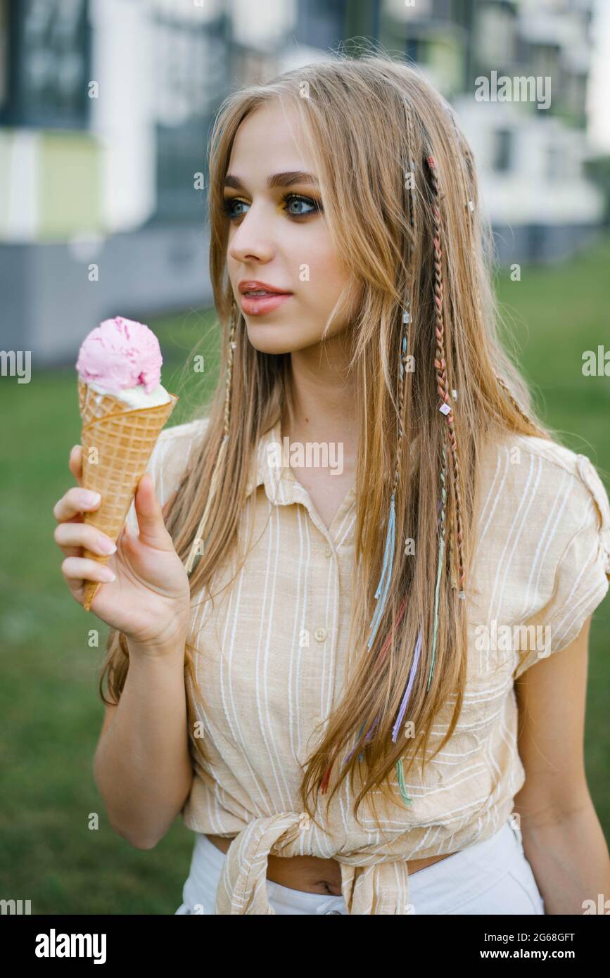 Nettes Mädchen isst Eis aus einem Waffelkegel und verschmutzt ihre Lippen Stockfoto