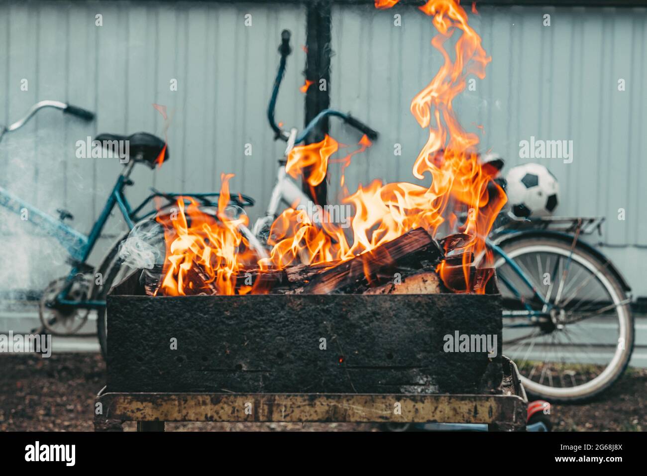 Eine helle Flamme aus dem Feuer. Flammen über dem Grill. Holzstäbchen im Feuer Stockfoto