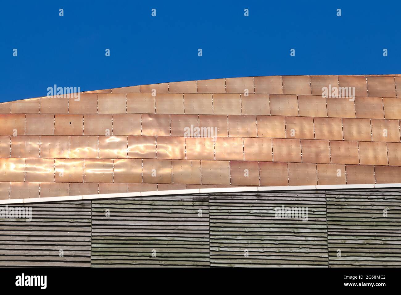 Goldene Bronze-Legierung Dachziegel in der Sommersonne vor einem klaren blauen Himmel leuchten Stockfoto