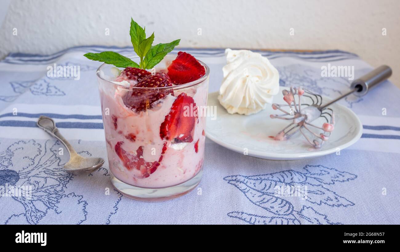 Eton Dessert mit Erdbeere, Rahm und weißem Ei-Baiser vermengen. Auf einem Tisch zur Seite peitschen. Stockfoto