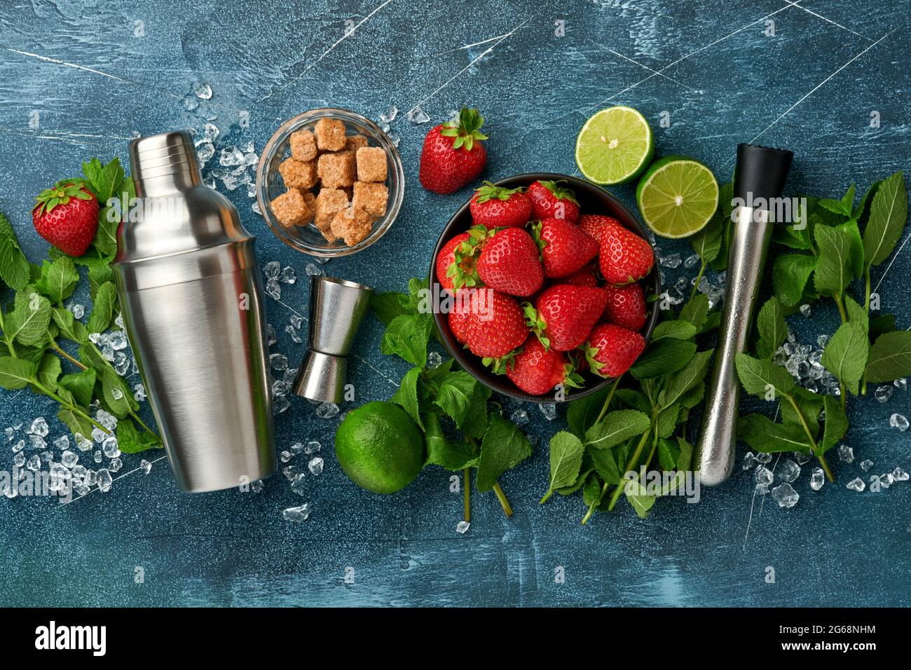 Lebensmittel Frische Zutaten für die Herstellung von Limonade, infundiert entgiftendes Wasser oder Cocktail. Erdbeeren, Limette, Minze, Basilikum, Rohrzucker, Eiswürfel und Shaker im Dunkeln Stockfoto