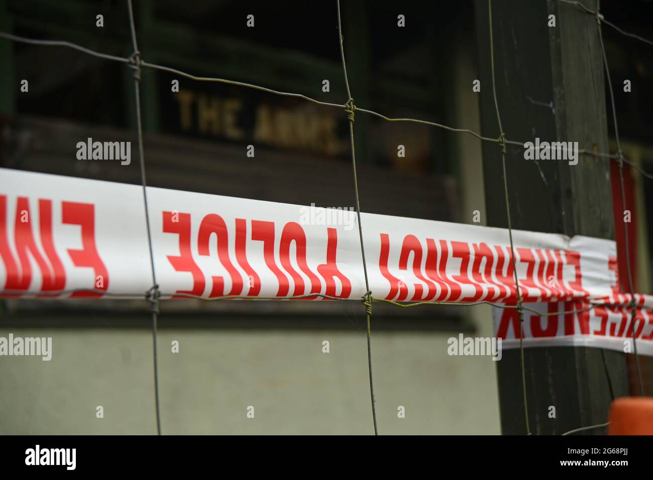 Notfallband der Polizei verhindert den öffentlichen Zugriff an einem vermuteten Tatort, der noch untersucht wird Stockfoto