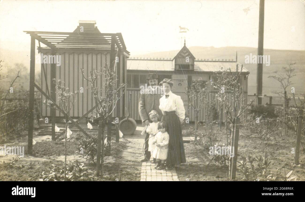 Porträt einer jungen Familie in ihrem Gemüsegarten neben ihrem Taubenloft um 1905 Stockfoto