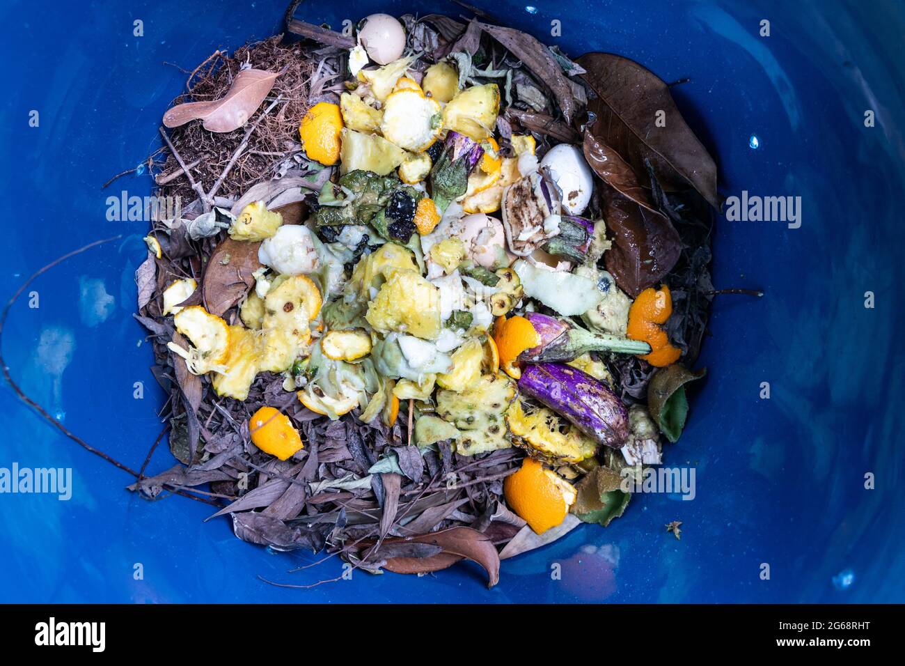 Mischung der grünen und braunen Materialien im Kompostbehälter Stockfoto