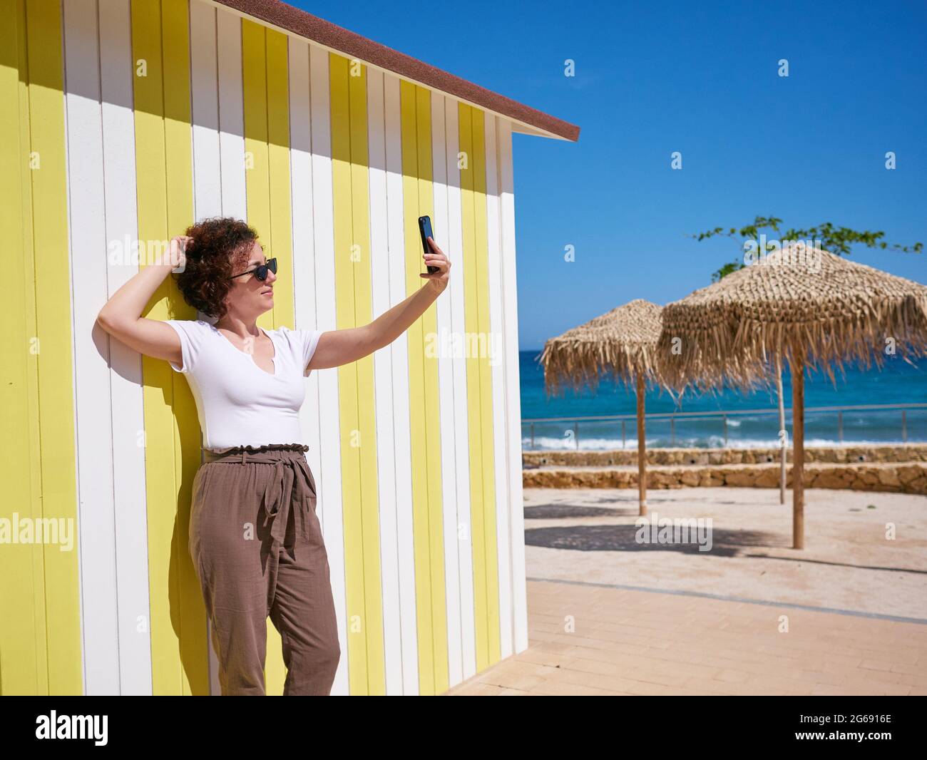 Frau, die während ihres Sommerurlaubs ein Selfie mit ihrem Mobiltelefon macht Stockfoto