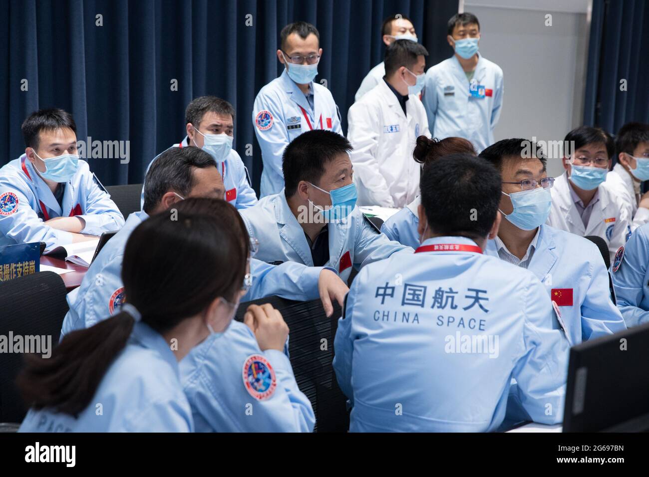 (210704) -- PEKING, 4. Juli 2021 (Xinhua) -- Technische Mitarbeiter arbeiten im Beijing Aerospace Control Center in Peking, der Hauptstadt Chinas, 4. Juli 2021. Chinesische Astronauten haben am Sonntag Extravehicular-Aktivitäten (EVAs) abgeschlossen und sind nach Angaben der China Manned Space Agency (CMSA) zum Kernmodul der Raumstation Tianhe zurückgekehrt. Die ersten EVAs während des Baus der Raumstation des Landes seien ein voller Erfolg, erklärte die CMSA. Die Shenzhou-12 Raumschiffcrew hat nach etwa 7 Stunden außerplanmäßiger Aktivitäten (EVAs) alle geplanten Aufgaben und die Astrona abgeschlossen Stockfoto