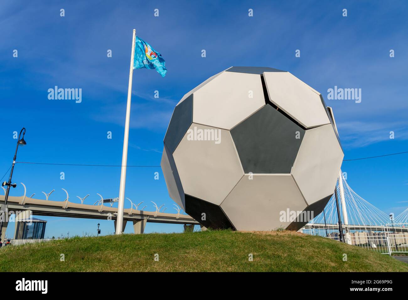Großer Fußball auf Gras Installation neben Fahnenstange mit UEFA EURO 2020 Flagge in der Stadt des Turniers, St. Petersburg, Russland Stockfoto