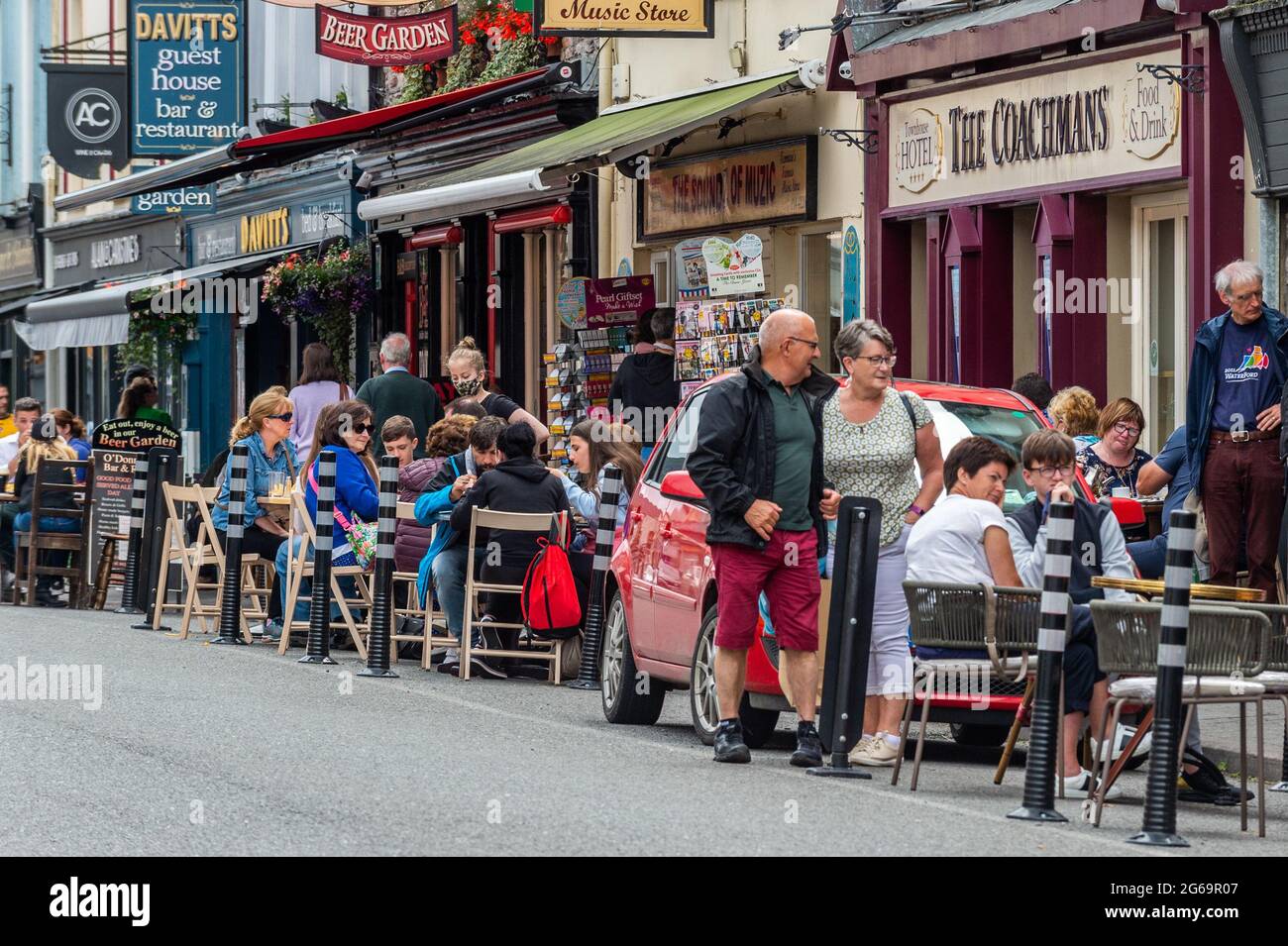 Kenmare, Co. Kerry, Irland. Juli 2021. Die Stadt Kenmare in Co. Kerry war heute sehr beschäftigt, da viele Menschen draußen essen, da die COVID-19-Beschränkungen es den Menschen verbieten, drinnen zu essen. Einige Leute trugen Gesichtsmasken, aber die meisten Touristen waren maskenfrei. Quelle: AG News/Alamy Live News Stockfoto