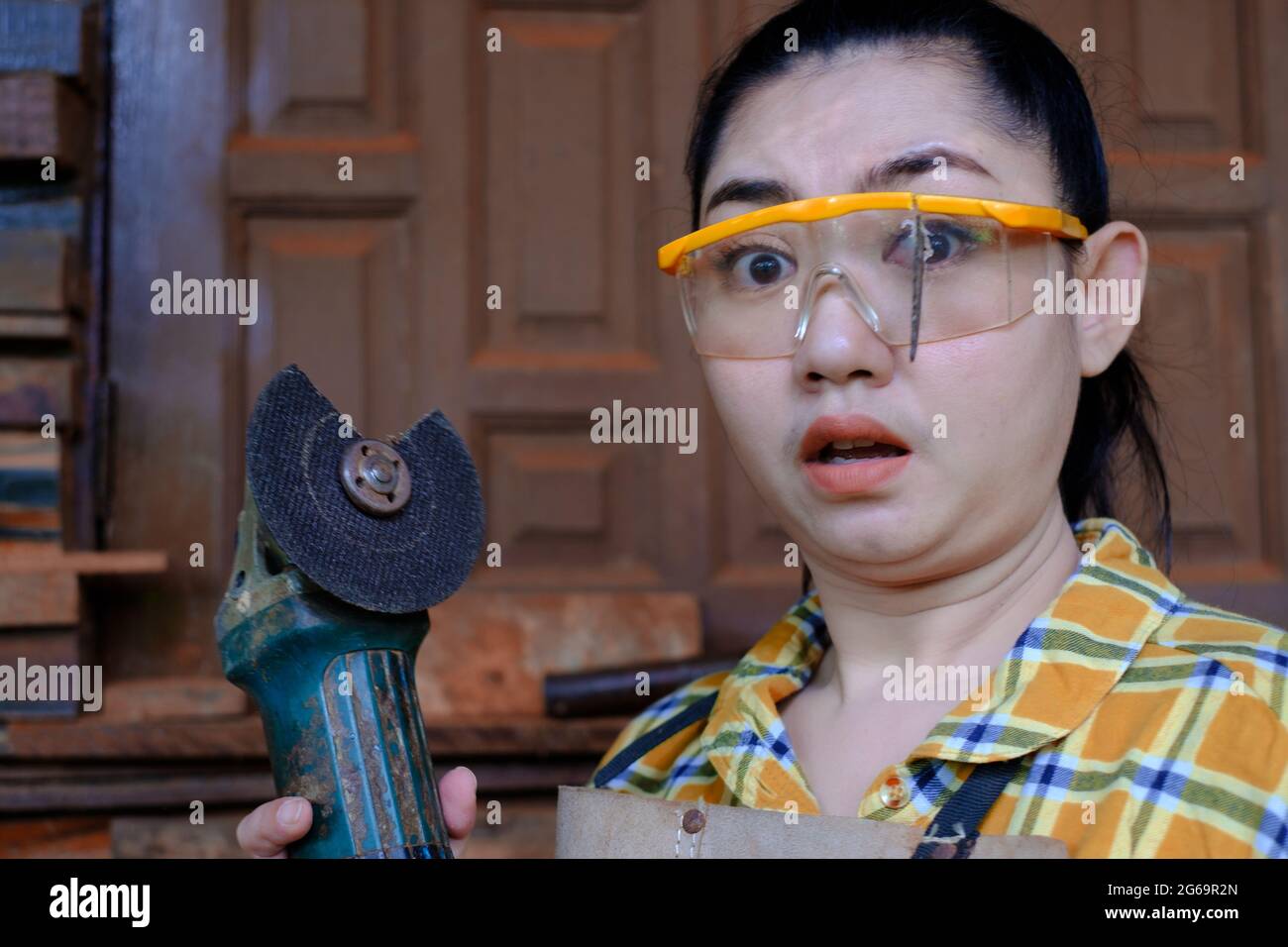 Tragen Sie eine Schutzbrille gerettet diese Technikerin Frau ist Auge, während der Arbeit, weil das Plugin Schneidescheibe gebrochen ist, Gefahren der Verwendung von Elektrowerkzeugen Stockfoto