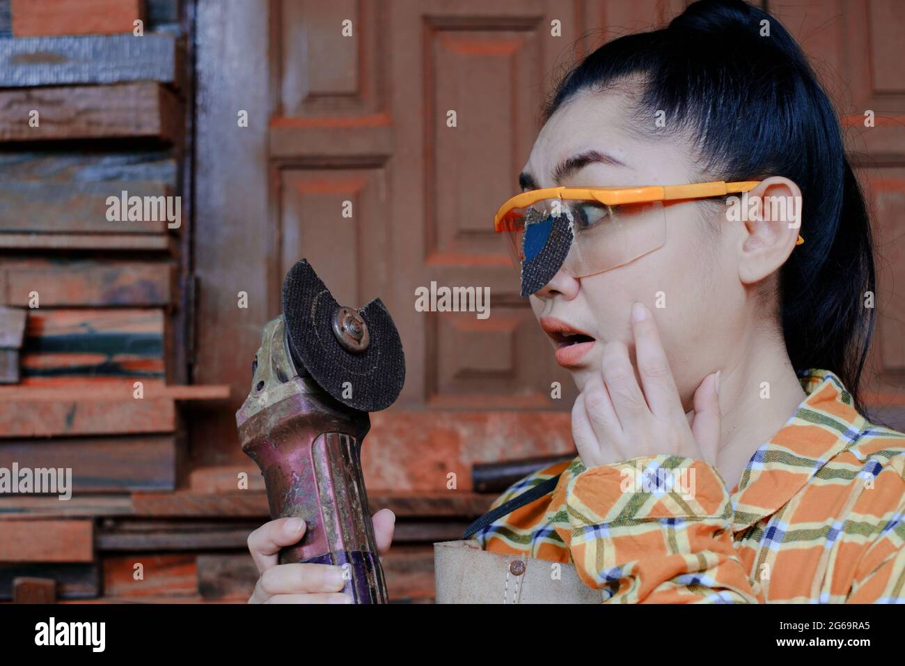 Tragen Sie eine Schutzbrille gerettet diese Technikerin Frau ist Auge, während der Arbeit, weil das Plugin Schneidescheibe gebrochen ist, Gefahren der Verwendung von Elektrowerkzeugen, Dies ist Stockfoto
