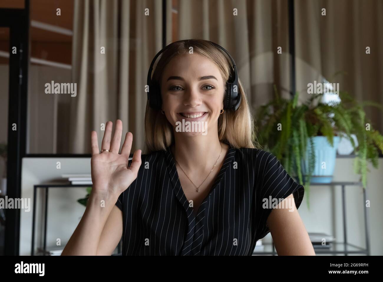 Porträt einer lächelnden Frau in einem Kopfhörer mit schwingenden Händen Stockfoto