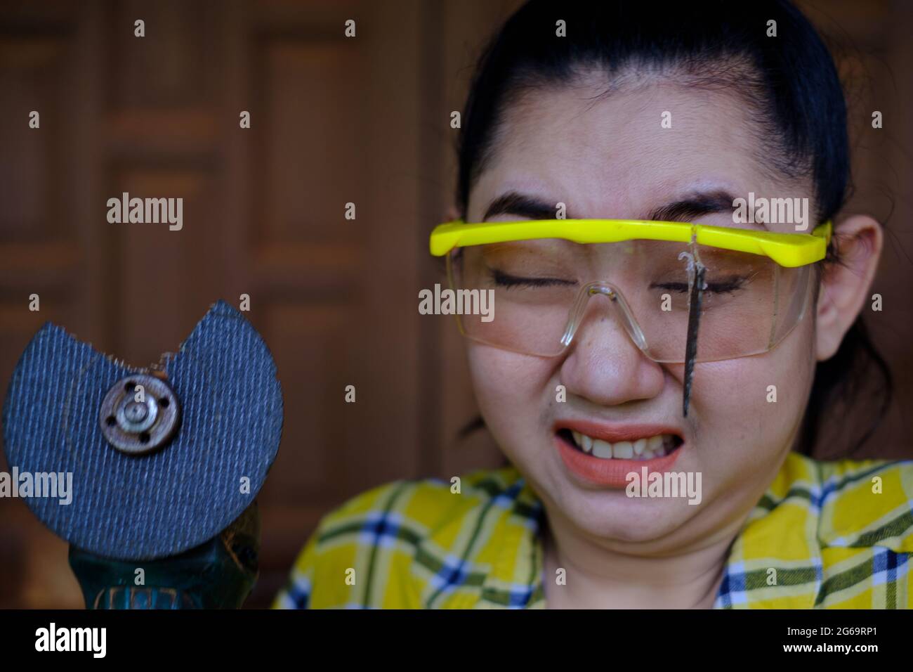 Tragen Sie eine Schutzbrille gerettet diese Technikerin Frau ist Auge, während der Arbeit, weil das Plugin Schneidescheibe gebrochen ist, Gefahren der Verwendung von Elektrowerkzeugen, Dies ist Stockfoto