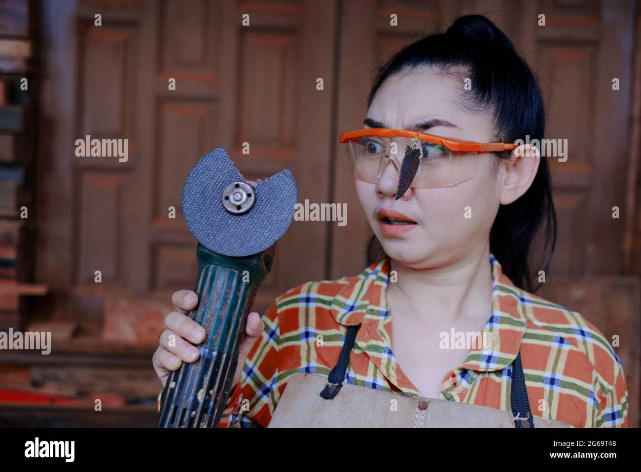 Tragen Sie eine Schutzbrille gerettet diese Technikerin Frau ist Auge, während der Arbeit, weil das Plugin Schneidescheibe gebrochen ist, Gefahren der Verwendung von Elektrowerkzeugen, Dies ist Stockfoto