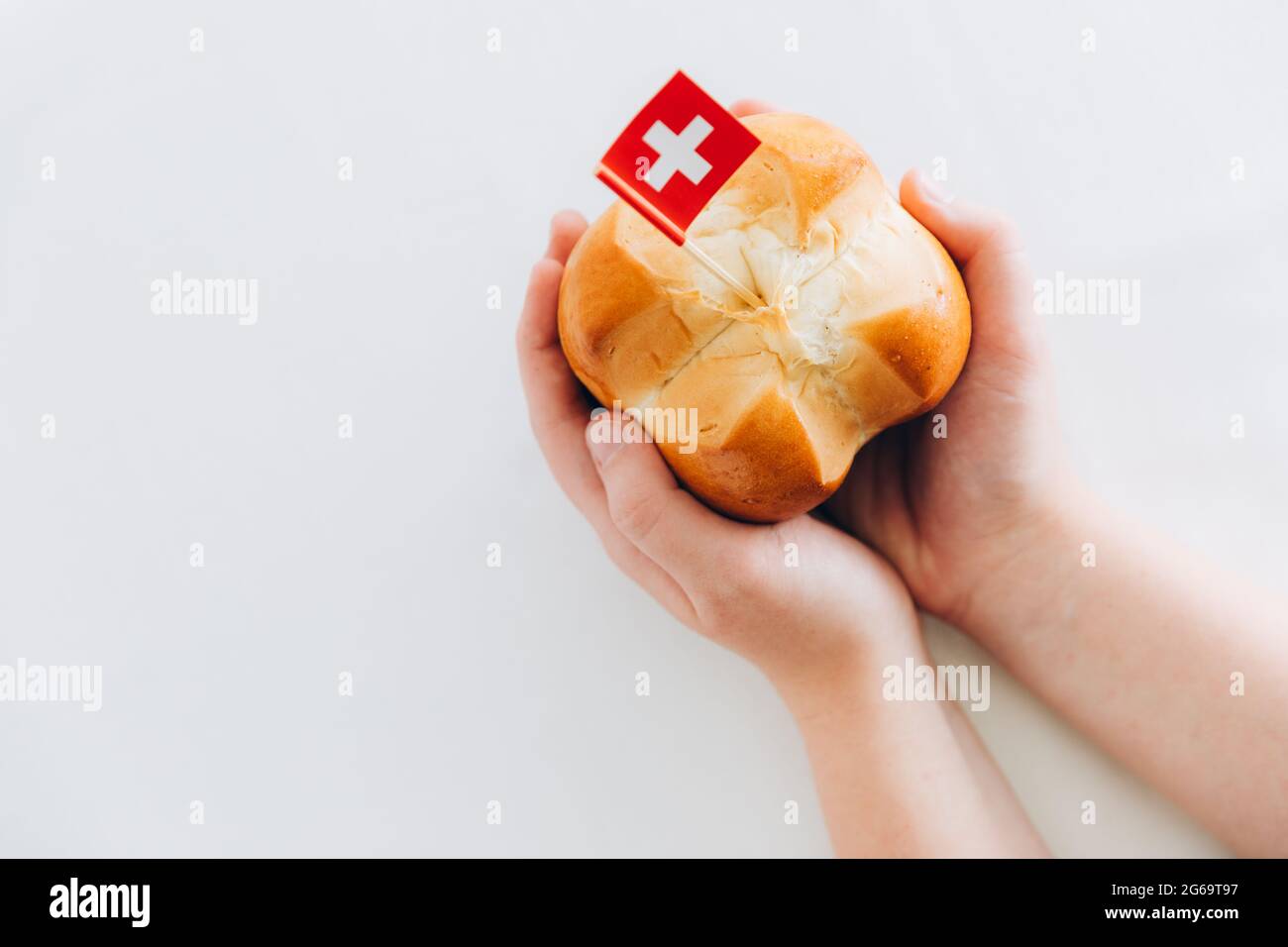 Der Schweizer Nationalfeiertag wird jährlich am 1. August in der Schweiz  mit traditionellem Brot, das auf Deutsch Augustweggen genannt wird,  gefeiert. Kinderhände mit einem Schlafzimmer Stockfotografie - Alamy