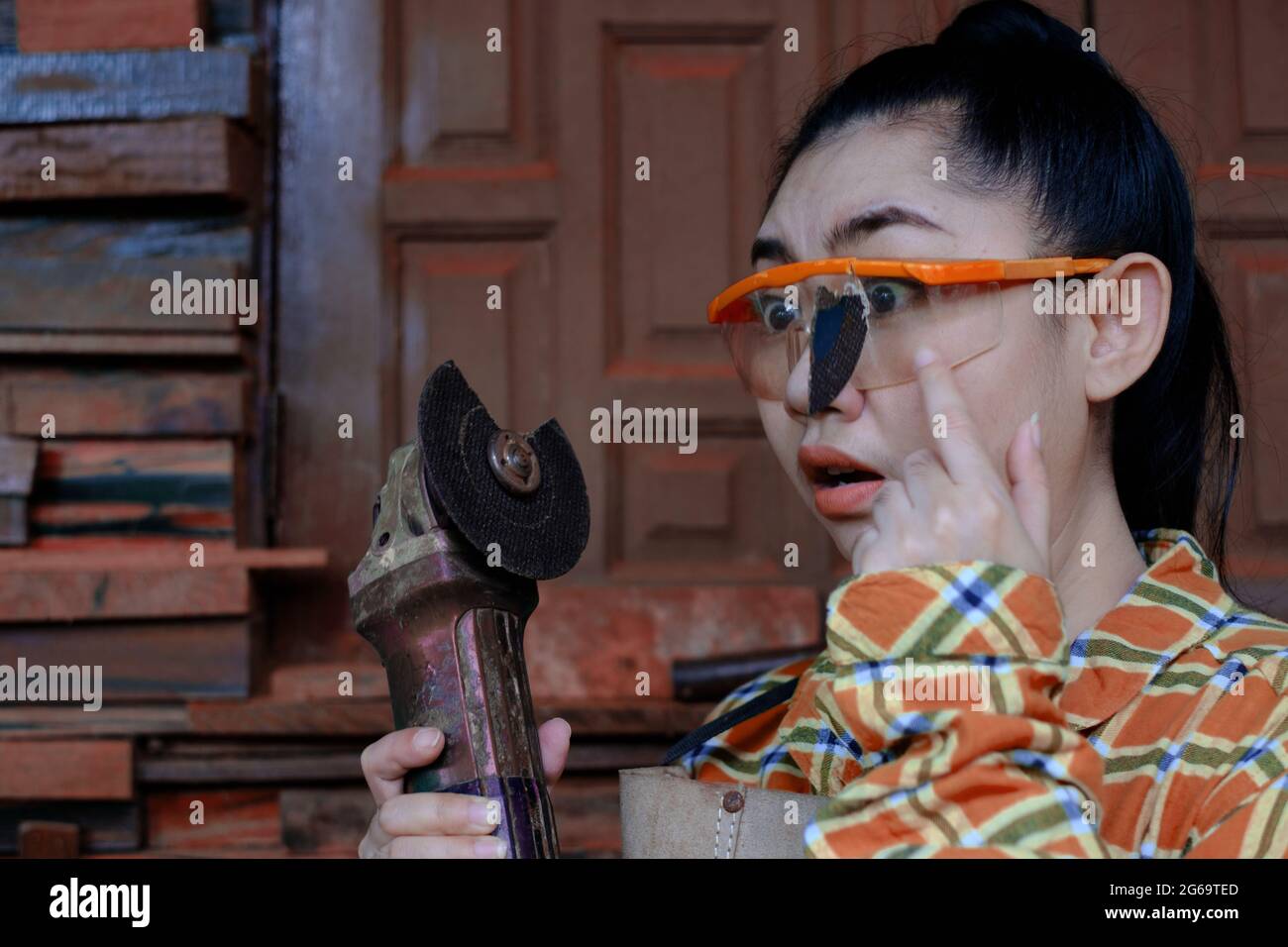 Tragen Sie eine Schutzbrille gerettet diese Technikerin Frau ist Auge, während der Arbeit, weil das Plugin Schneidescheibe gebrochen ist, Gefahren der Verwendung von Elektrowerkzeugen, Dies ist Stockfoto