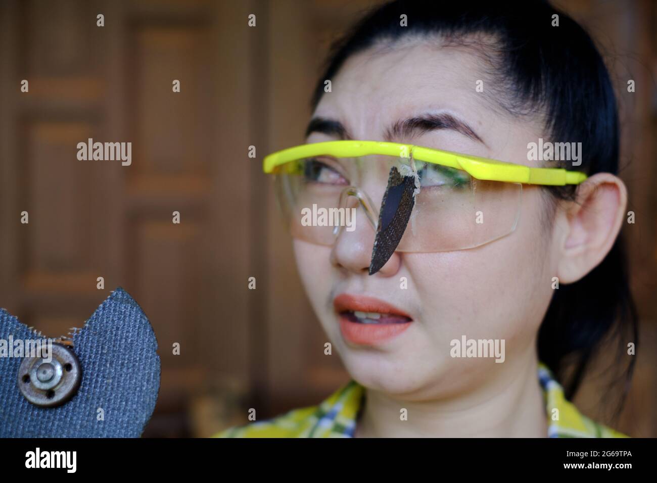 Tragen Sie eine Schutzbrille gerettet diese Technikerin Frau ist Auge, während der Arbeit, weil das Plugin Schneidescheibe gebrochen ist, Gefahren der Verwendung von Elektrowerkzeugen, Dies ist Stockfoto