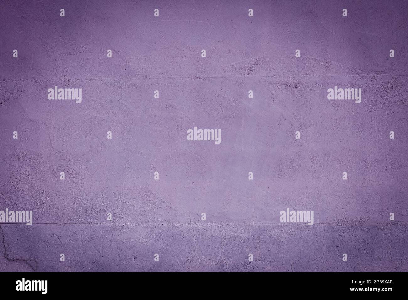 Violette Gipswand mit dunklen Vignetten-Rändern, grungenem Hintergrund oder Textur Stockfoto