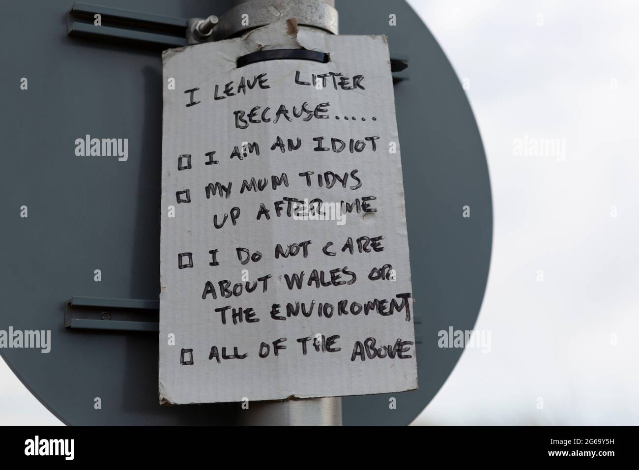 Humorvolles, handgemachtes Schild, das die Menschen ermutigt, ihren Abfall mit nach Hause zu nehmen. Aufgenommen in Pembrey Sands, Carmarthenshire, Wales. Stockfoto