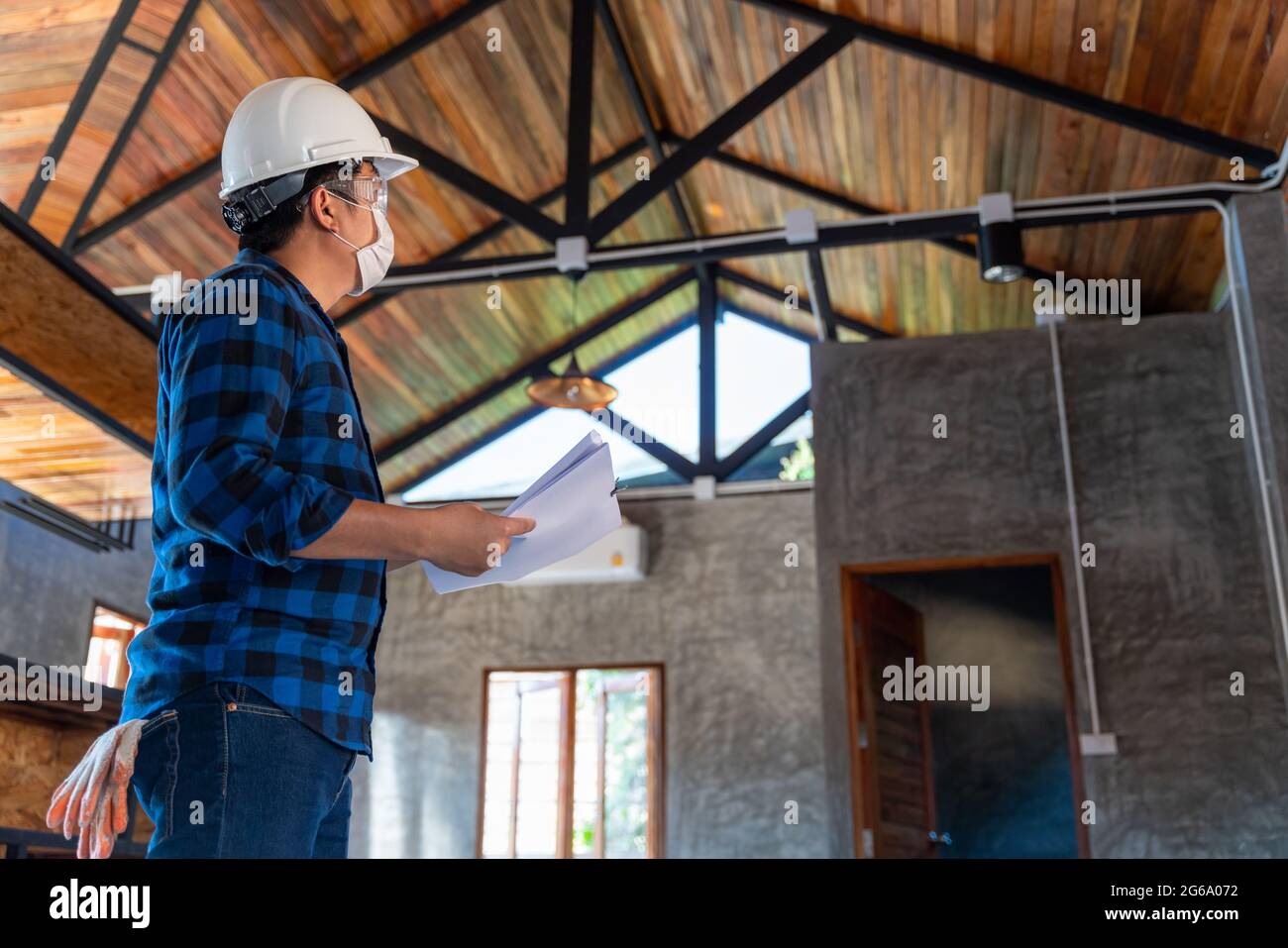 Der Techniker des Bauingenieurs inspiziert die Struktur unter dem Dach auf der Baustelle oder auf der Baustelle eines Hauses. Stockfoto