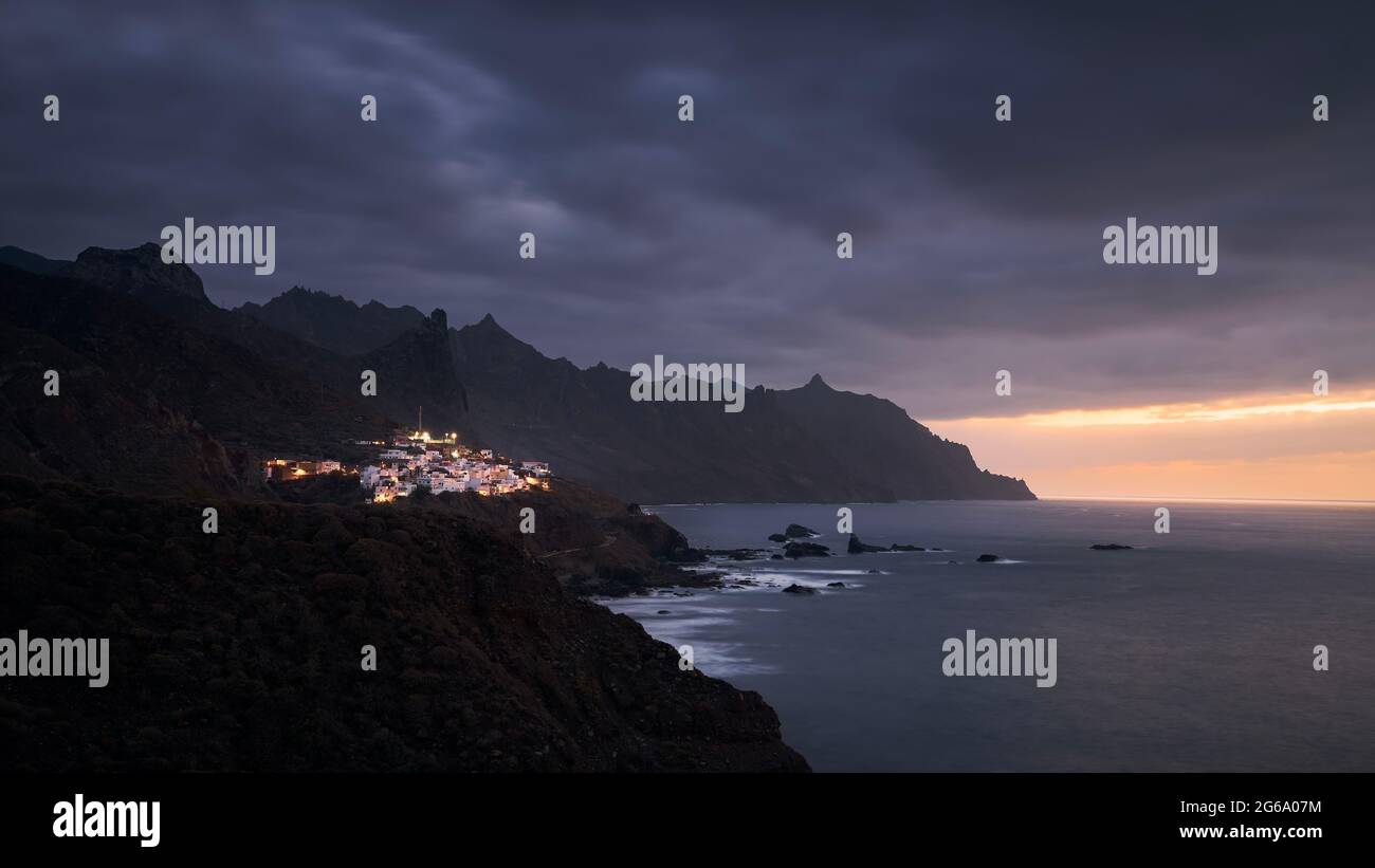 Klippen an der Nordküste von Teneriffa bei stimmungsvollen Sonnenuntergang. Dorf in den Bergen von Anaga, Teneriffa, Kanarische Inseln, Spanien. Stockfoto