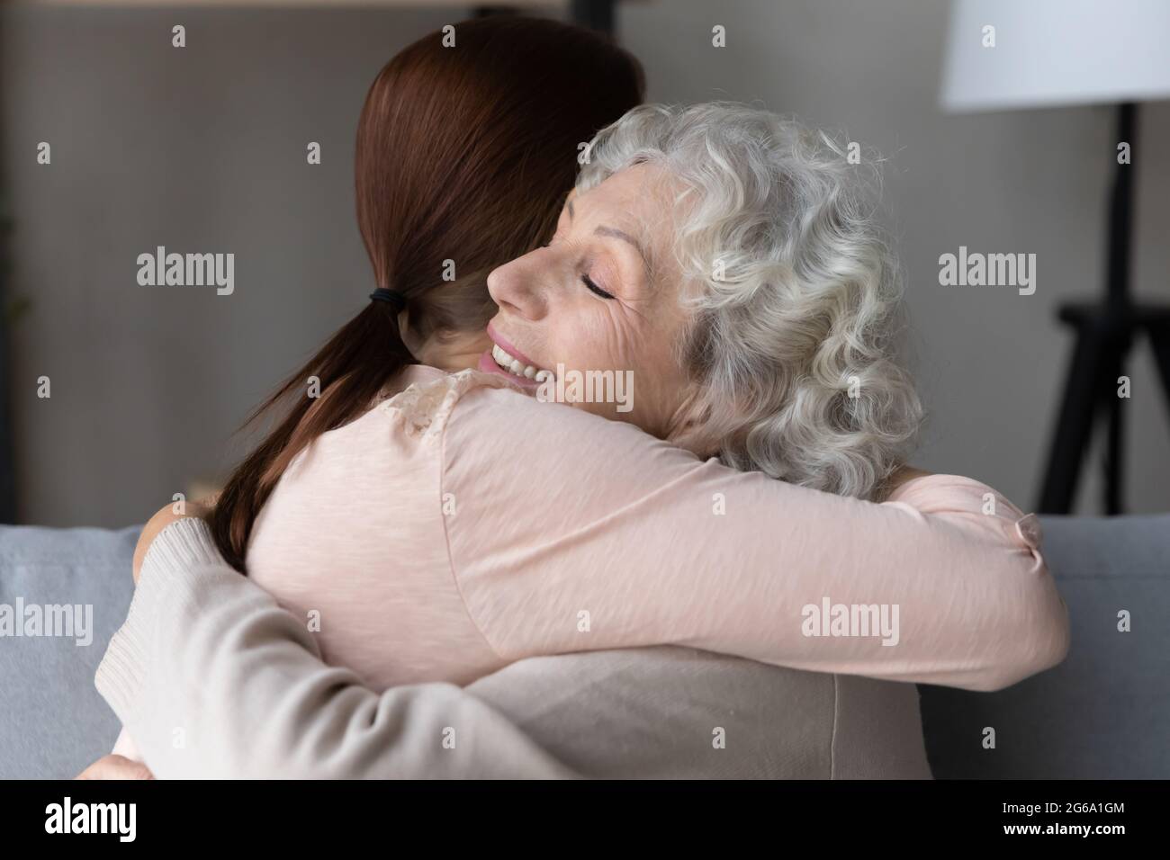 Dankbare ältere Großmutter Rentner halten in den Armen Erwachsene Enkelin Stockfoto