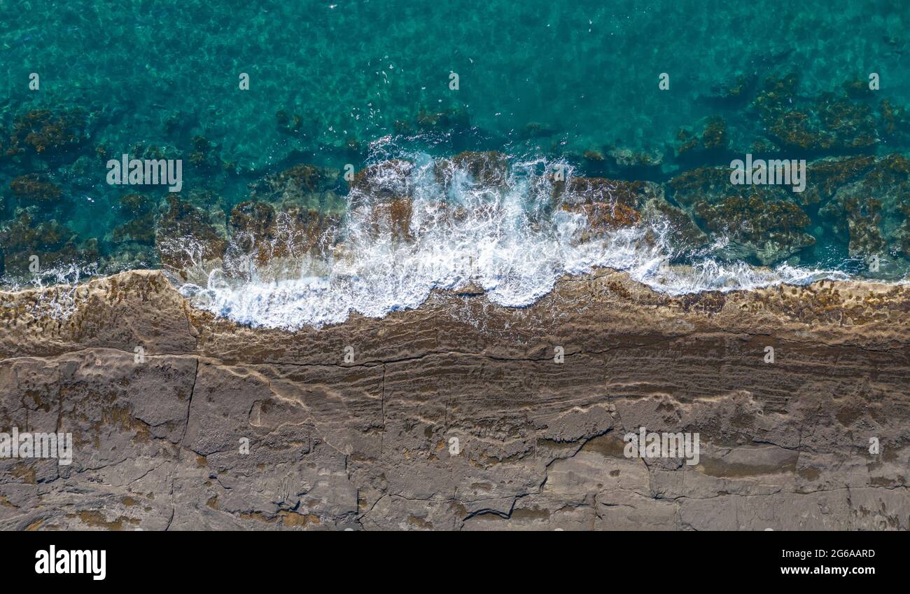 Luftpanorama der felsigen Küste mit brechenden Wellen in der Nähe von Pomos, Zypern Stockfoto