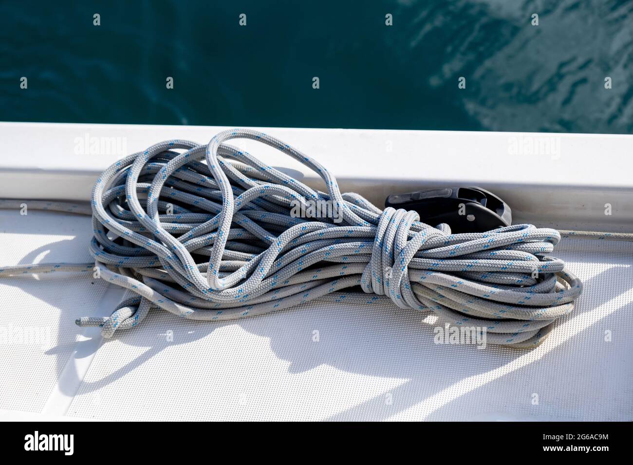 Verankerungsseile auf dem Segelbootdeck im Hintergrund. Graues Segelseil am Schiffsbogen, Nahaufnahme, Segelbootsfahrt in der Ägäis, Griechenland Stockfoto