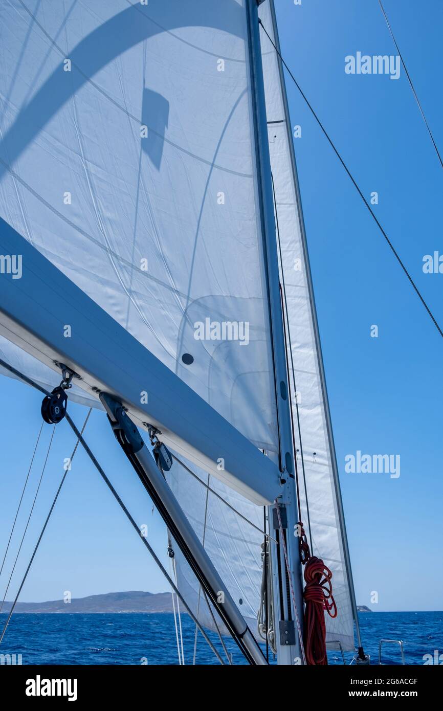 Segelboot Deck, Bug, Mast und Segel Nahaufnahme. Weiße sloop manipulierte Yacht segelt im offenen, ruhigen Ozean, blauer Himmel im Hintergrund, sonniger Tag. Ägäisches Meer saili Stockfoto