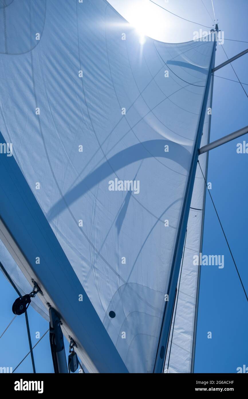 Segeln mit dem Wind am offenen Meer, Sommerurlaub Konzept. Die Segel des Yachtwindes wurden auf dem Hintergrund des klaren blauen Himmels aufgefüllt. Blick in den Himmel, Sonne sh Stockfoto