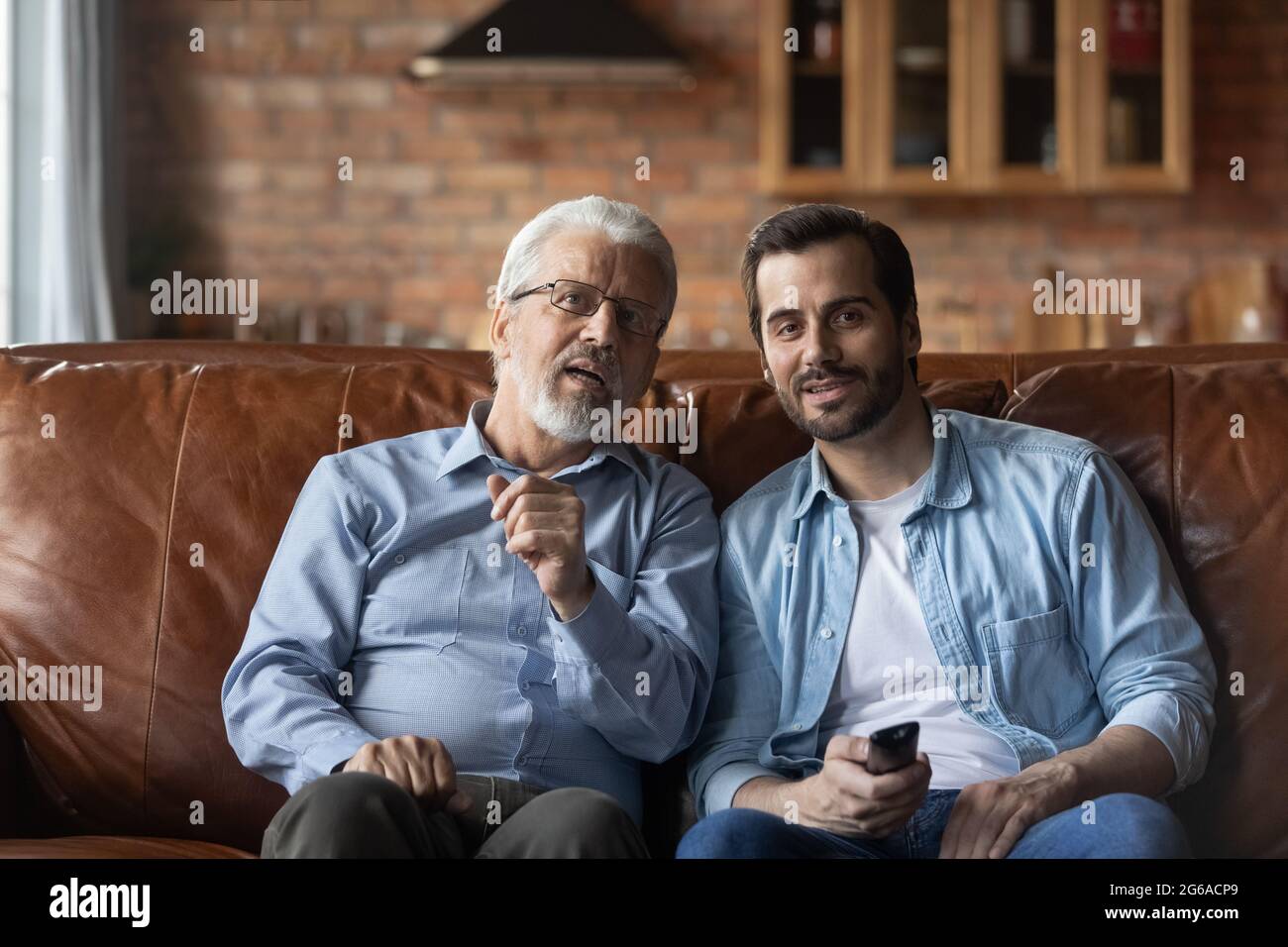 Aufgeregt verlobt erwachsenen Sohn und älteren Vater Film zu sehen Stockfoto