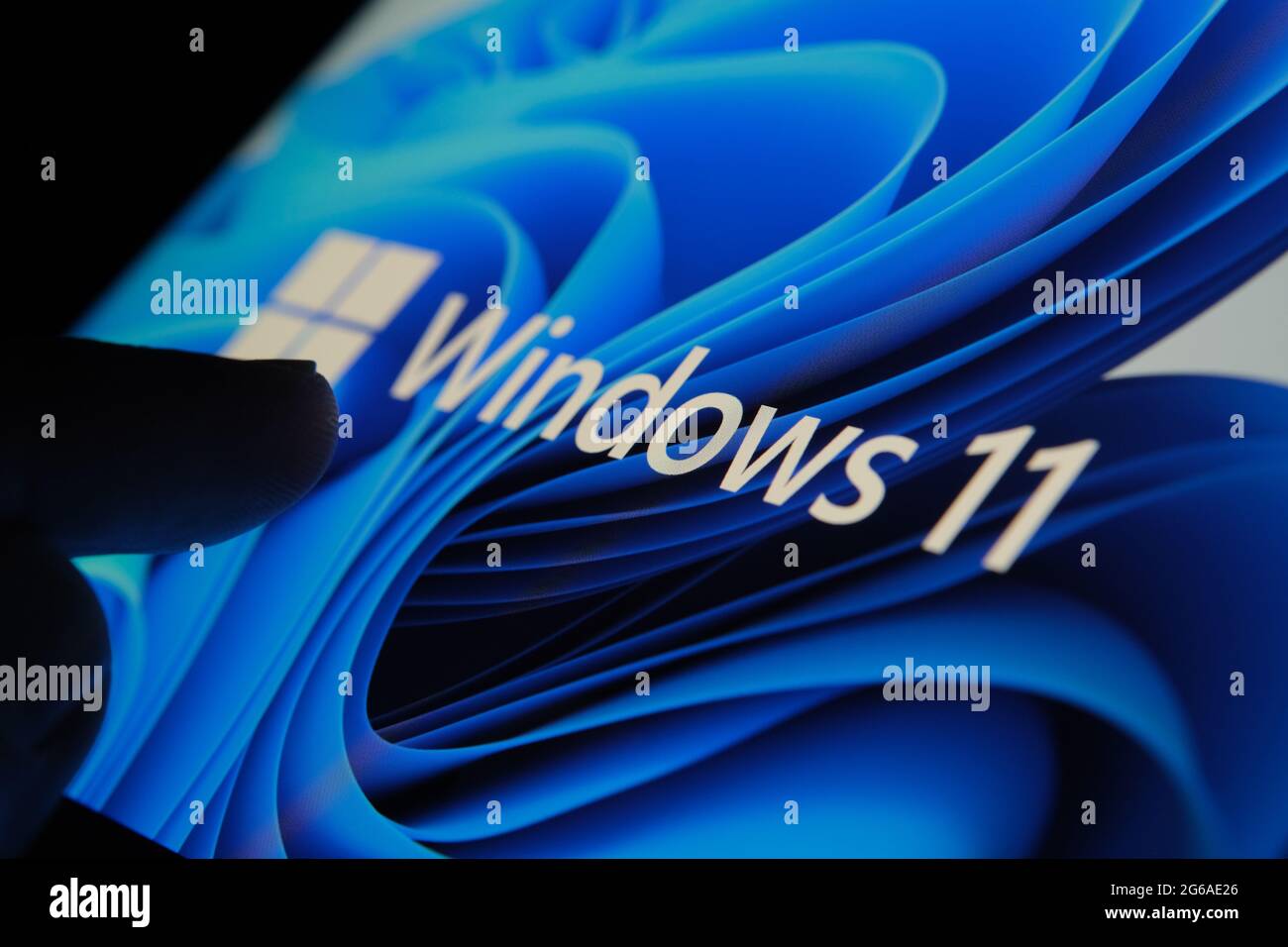 Windows 11-Logo auf dem Bildschirm des Tablets und Benutzer mit dem Finger auf sie zu sehen. Stafford, Großbritannien, 1. Juli 2021 Stockfoto