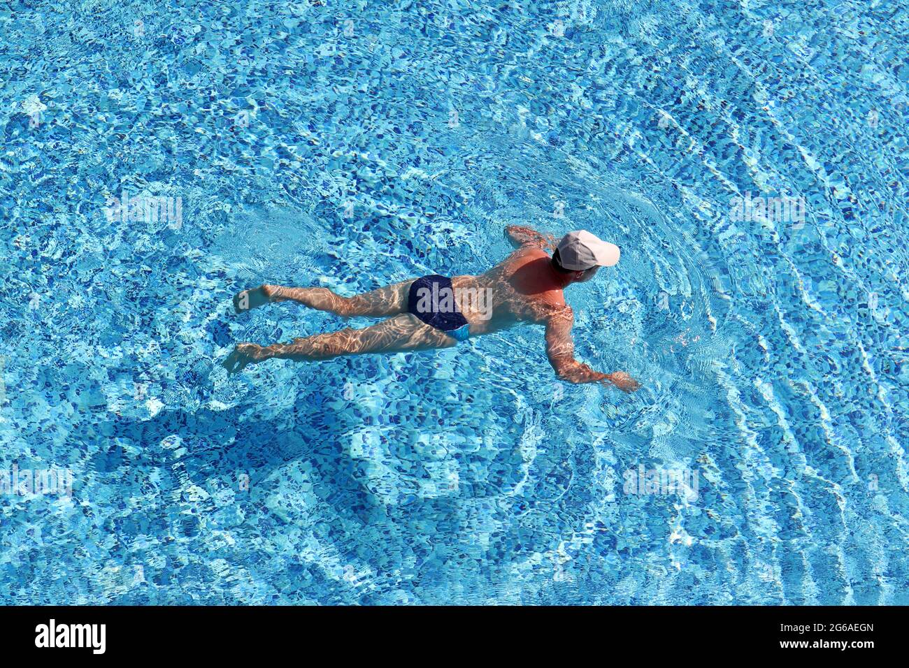 Mann schwimmend in einem Pool, Luftaufnahme. Sommerurlaub, Wassersport Stockfoto