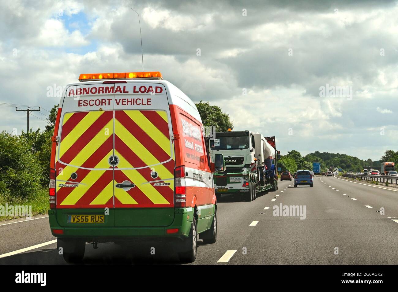 Swindon, England - 2021. Juni: Fahrzeug mit Blinklicht, das eine abnorme Last auf der Autobahn M4 begleitet Stockfoto