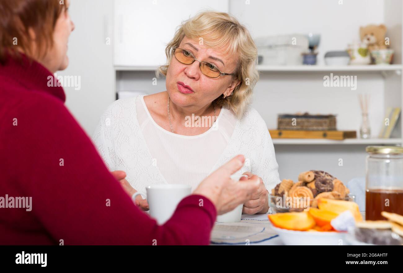 Gestresste ältere Frau im Gespräch mit Frau Stockfoto