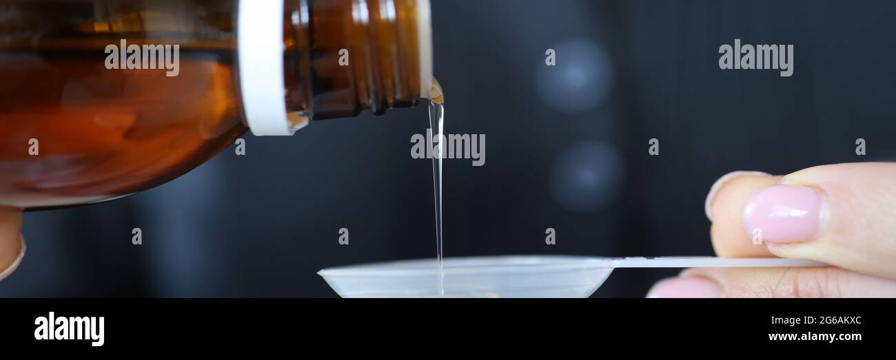 Die Hand der Frau gießt kalten Sirup in den Löffel Stockfoto