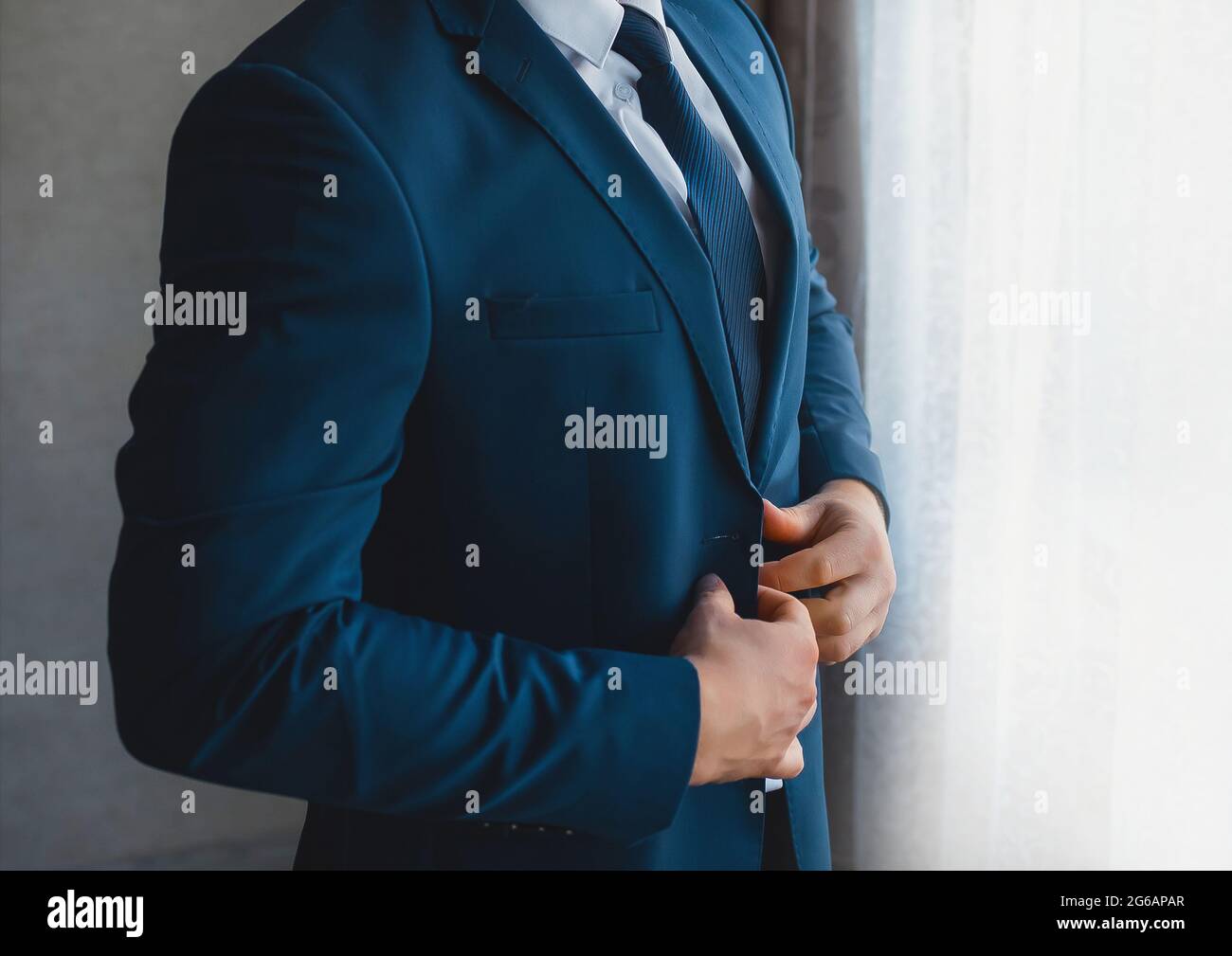 Business und seriöse Mann Geschäftsmann in weißem Hemd, blaue Krawatte und Anzug steht am Fenster. Stockfoto