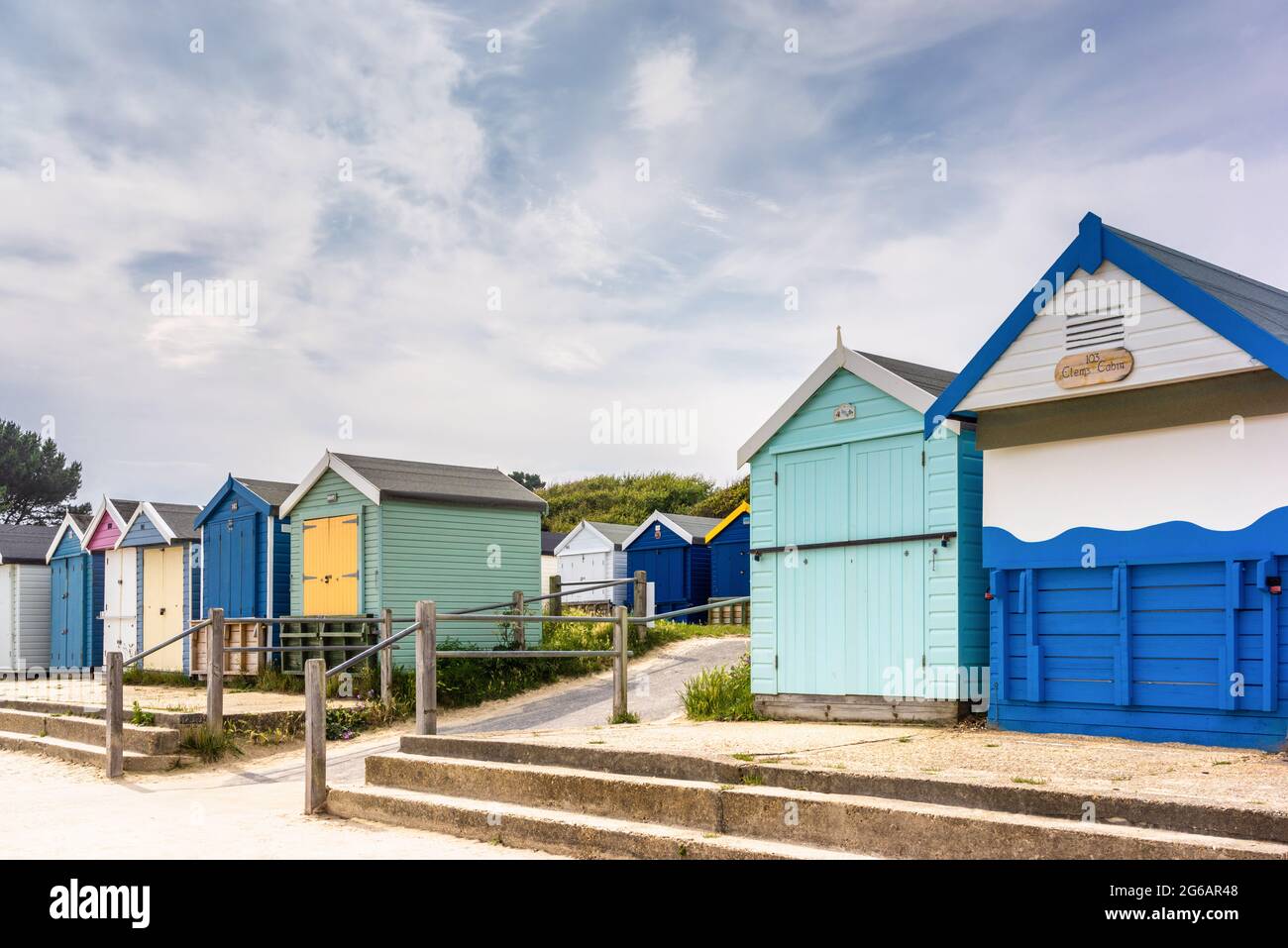 Bunte Strandhütten in Reihen am Friars Cliff Beach in Dorset, England, Großbritannien Stockfoto