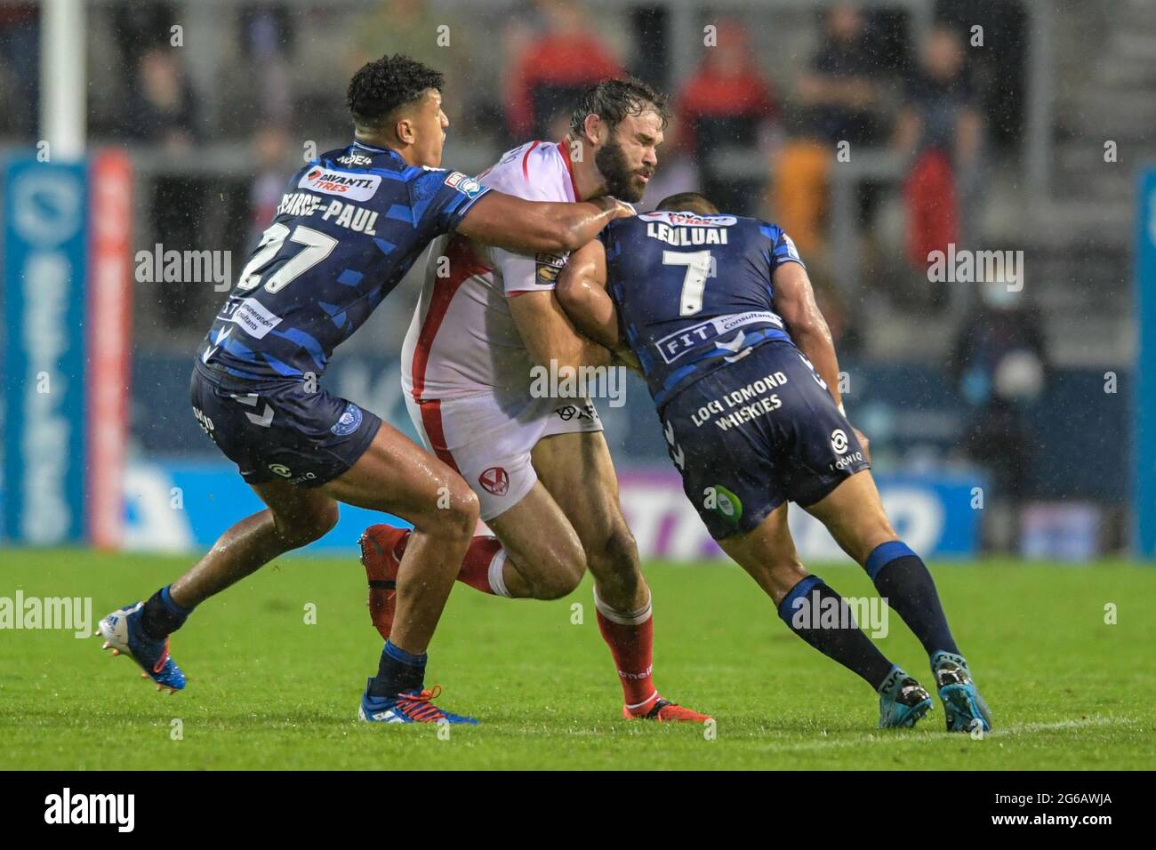 Alex Walmsley (8) aus St. Helens wird am 7/4/2021 von Kai Pearce-Paul (27) aus Wigan Warriors und Thomas Leuluai (7) aus Wigan Warriors in St. Helens, Großbritannien, angegangen. (Foto von Simon Whitehead/ SW Photo/News Images/Sipa USA) Stockfoto