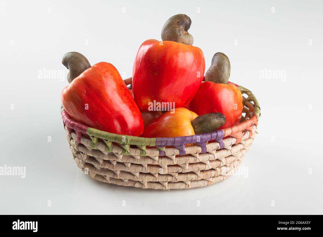 Frische reife Cashew-Früchte isoliert in Korb mit weißem Hintergrund Stockfoto