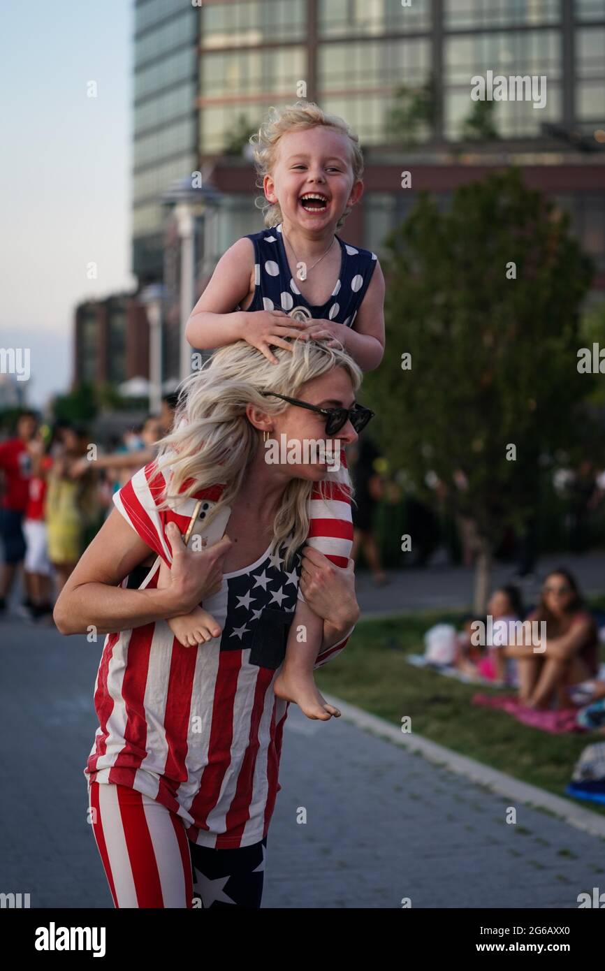 New York, USA. Juli 2021. Ein junges Mädchen lacht auf den Schultern ihrer Mutter vor dem Feuerwerk des Macy am 4. Juli in New York, USA. Kredit: Chase Sutton/Alamy Live Nachrichten Stockfoto