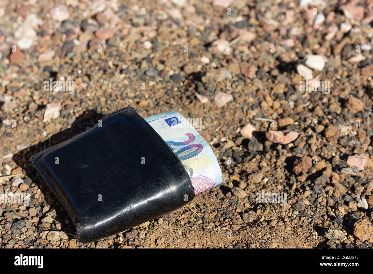 Schwarze Brieftasche auf schmutzigen Boden mit 20 Euro Scheine Rechnung. Verlorenes Geld, Glückskonzepte Stockfoto