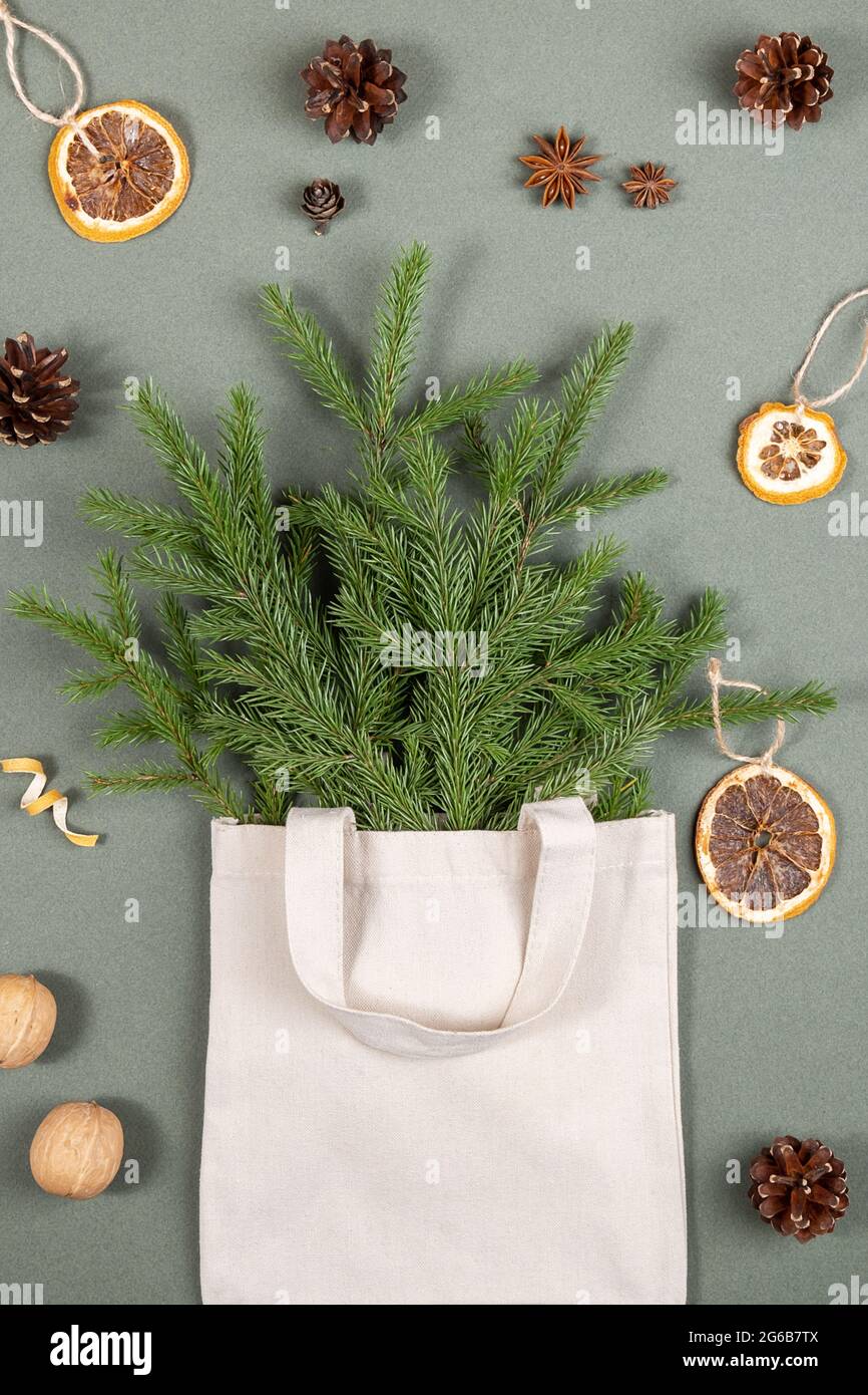 Bouquet von Tannenzweigen in Stoff Öko-Tasche und umweltfreundliche natürliche Einrichtung auf grünem Hintergrund. Konzept weihnachten Null Verschwendung. Draufsicht Flat Lay. Stockfoto