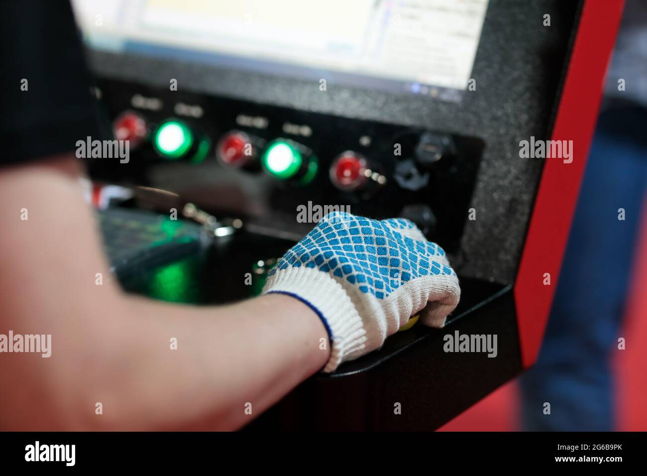 Arbeiter steuert moderne computerisierte Maschine in Metallbearbeitungsanlage. Selektiver Fokus. Stockfoto