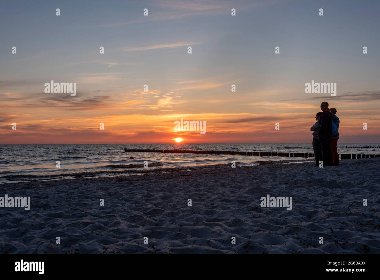 Hiddensee, Deutschland. Juni 2021. Urlauber stehen am Strand von Vitte und genießen einen farbenfrohen Sonnenuntergang. Jedes Jahr kommen viele Tausend Touristen auf die kleine Ostseeinsel, die wie ein Wellenbrecher die Westküste Rügens schützt. Die Insel wird von den Einheimischen auch "Dat söte Länneken" genannt. Quelle: Stephan Schulz/dpa-Zentralbild/ZB/dpa/Alamy Live News Stockfoto