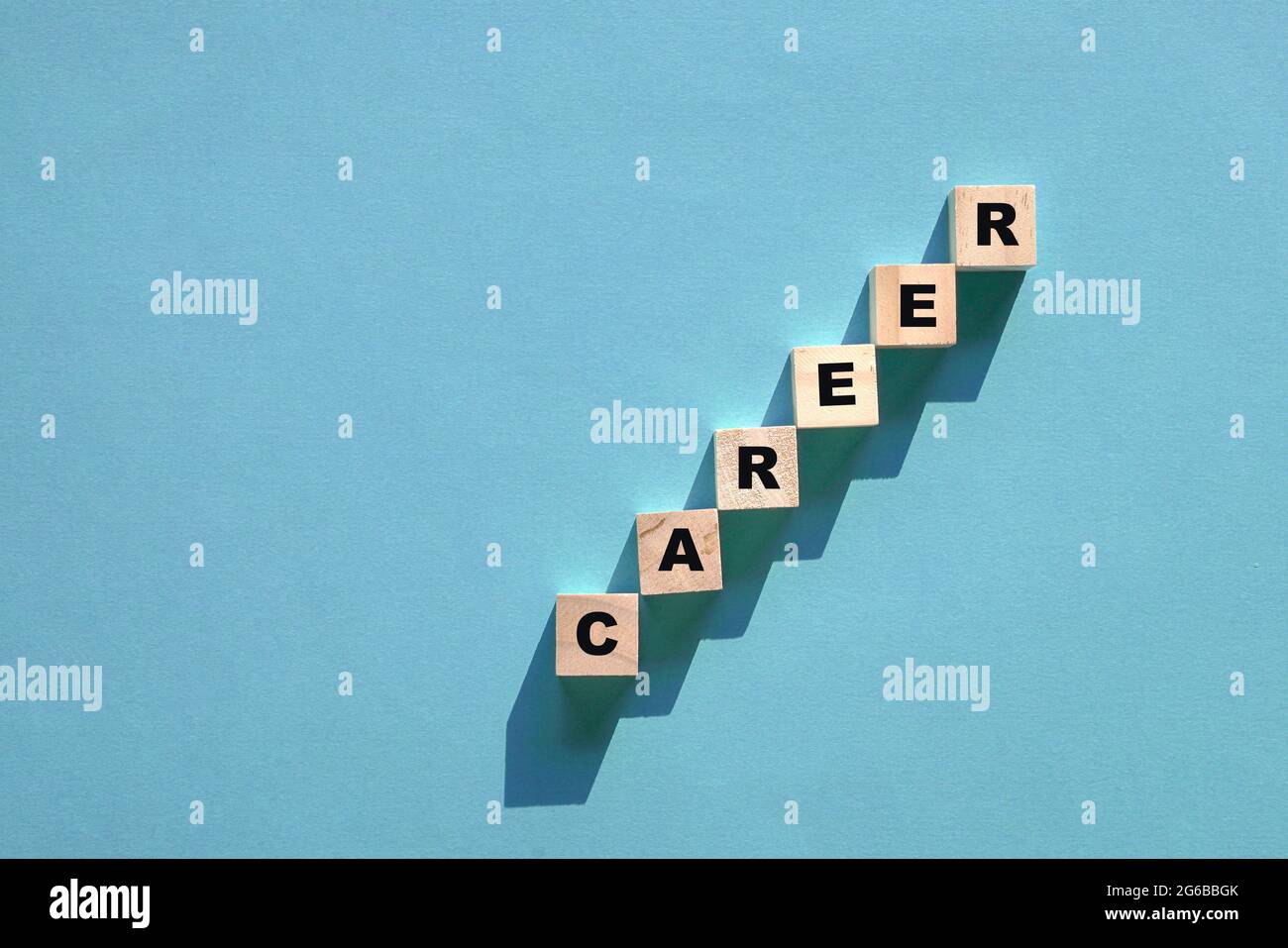 Karriere getipptes Wort auf Holzwürfeln, die in Leiterstufen angeordnet sind. Auf blauem Hintergrund Platz kopieren. Stockfoto