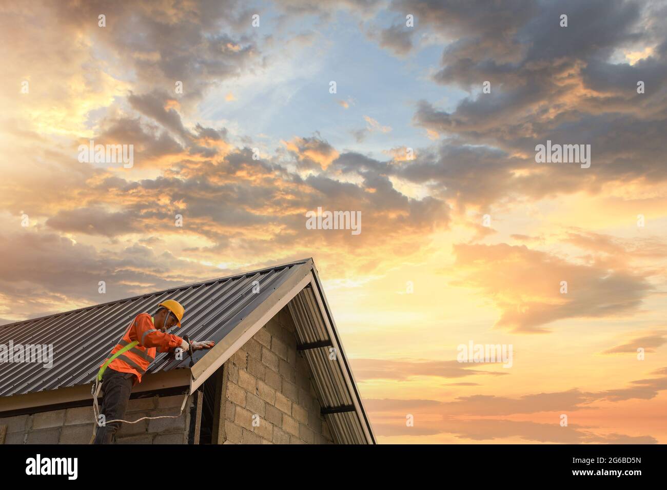 Bauarbeiter Montage von Metallblechen auf einem Dach, Thailand Stockfoto